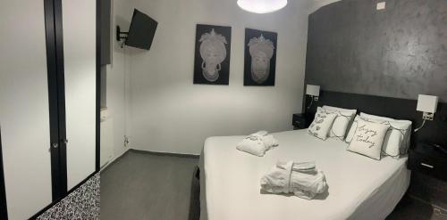 una camera da letto con un letto con lenzuola e cuscini bianchi di Appartamento Camilla a Siniscola