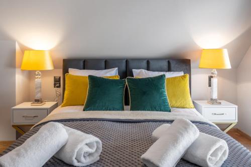 a bedroom with a bed with green and yellow pillows at Rezydencja Strążyska & Chalet BBQ in Zakopane