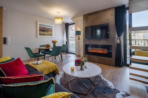 a living room with a couch and a fireplace at Rezydencja Strążyska & Chalet BBQ in Zakopane