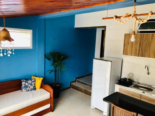 una cocina con paredes azules y un sofá en una habitación en Flat Meier, en Canoa Quebrada