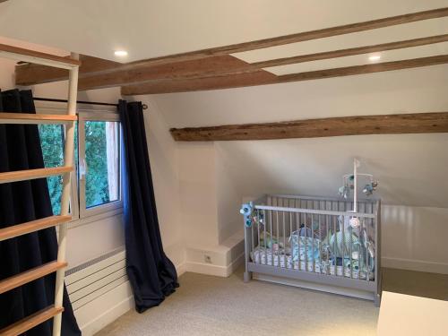 Grange Rousselin في Bachivillers: غرفة بها سرير أطفال ونافذة