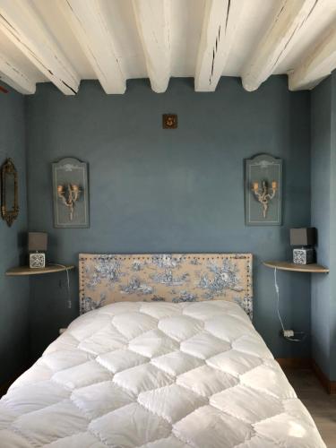 sypialnia z białym łóżkiem i niebieską ścianą w obiekcie Sainte-Suzanne gîte de LA FERME calme et tranquille w mieście Les Baux-de-Breteuil