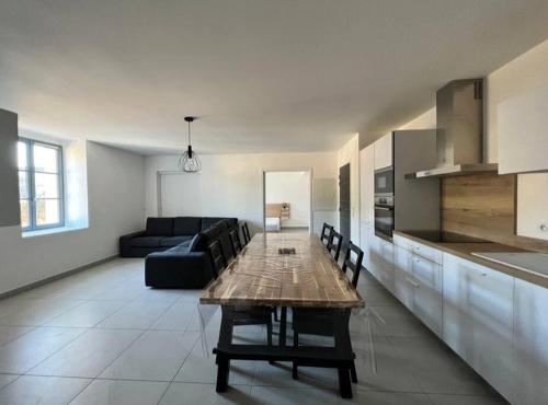 Il dispose d'une cuisine et d'un salon avec une table et un canapé. dans l'établissement Les Hauts du Port-Appartement neuf sur le port, à Bonifacio