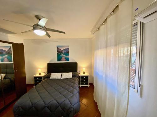 a bedroom with a bed and a ceiling fan at Casa 3 habitaciones y Piscina de temporada compartida - - Jacuzzi Spa No incluido -- By TrassierraRooms in Córdoba