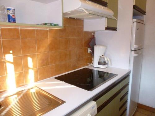 une petite cuisine avec un évier et un réfrigérateur dans l'établissement Villa 2 chambres dans résidence avec piscine 700m plage, à Cavalaire-sur-Mer
