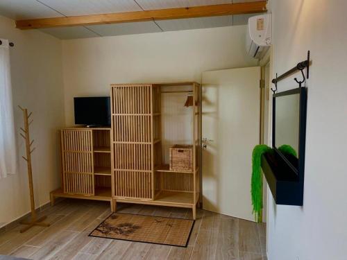 a room with a room with a shower and a television at טורקיז in Sede Neẖemya