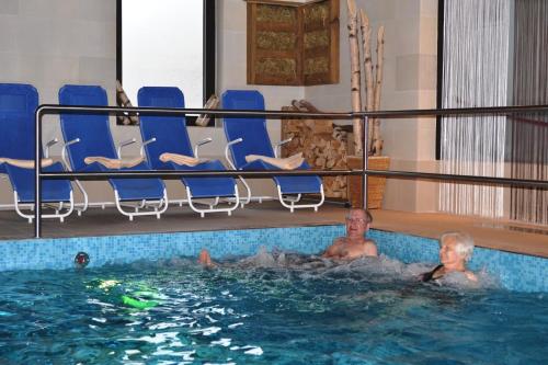 a man and a child in a swimming pool at Landhotel Spessartruh in Frammersbach