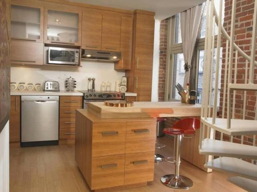 a kitchen with wooden cabinets and a counter top at Loft au coeur du Vieux-Québec in Quebec City