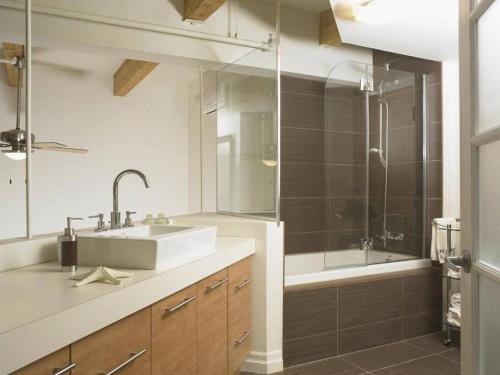 a bathroom with a sink and a shower and a tub at Loft au coeur du Vieux-Québec in Quebec City