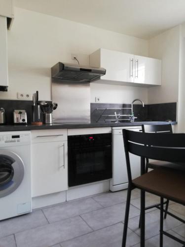 - une cuisine avec des appareils blancs, une table et une chaise dans l'établissement 65m with small balcony - near naval base, à Toulon