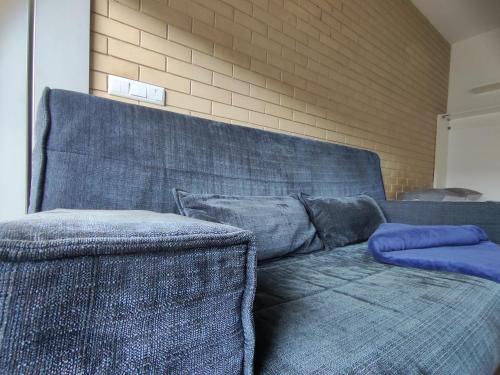 a blue couch with two pillows on it at T0 no centro do Porto in Porto