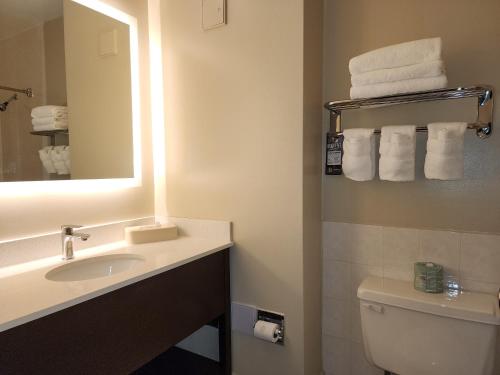 La salle de bains est pourvue d'un lavabo, d'un miroir et de toilettes. dans l'établissement Super 8 by Wyndham Thunder Bay, à Thunder Bay