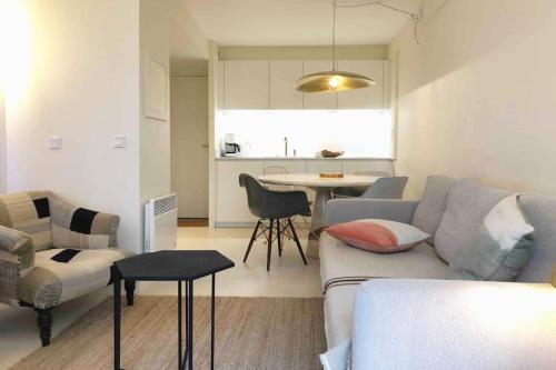 a living room with a couch and a table at Appartement 2 chambres COULEUR DUNE, piscine, parking gratuit in Le Touquet-Paris-Plage