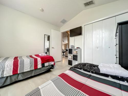 - 2 lits dans une chambre aux murs blancs dans l'établissement Gorgeous Pool Home Near Disney - 2024 specials!, à Davenport