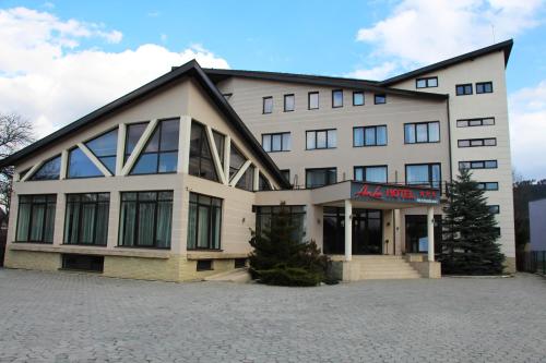 a large white building with a sign on it at Hotel Ave Lux in Braşov