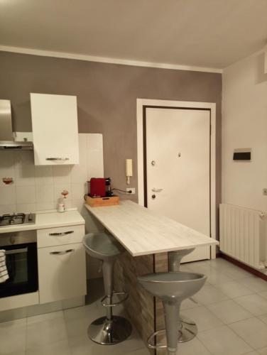 a kitchen with a counter and stools in it at Appartamento La Libellula in Grosseto