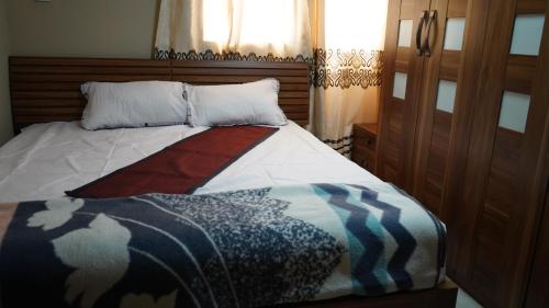 a bedroom with a bed with a blanket on it at Maajob Resort in Brikama