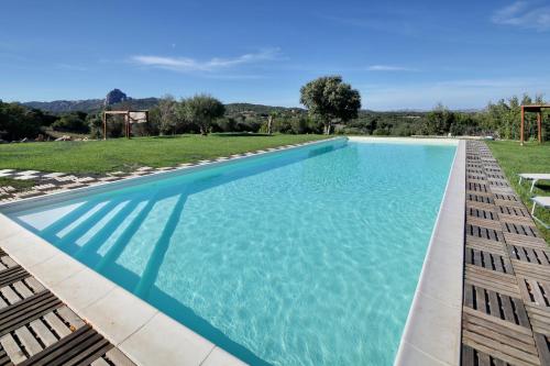 a swimming pool with blue water in a yard at Sardinia Green Park Country Lodge in Olbia