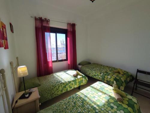 Zimmer mit 2 Betten und einem Fenster in der Unterkunft Manuel Agustín Heredia in Málaga