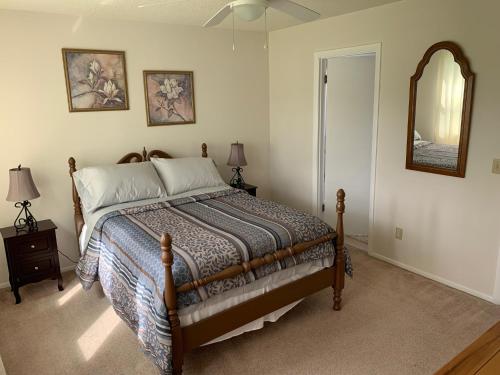 1 dormitorio con cama y espejo en la pared en The 106 Lake House en Lake Placid