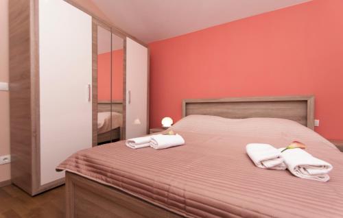 1 dormitorio con paredes rojas y 1 cama con toallas en Apartment Frlan, en Vela Luka