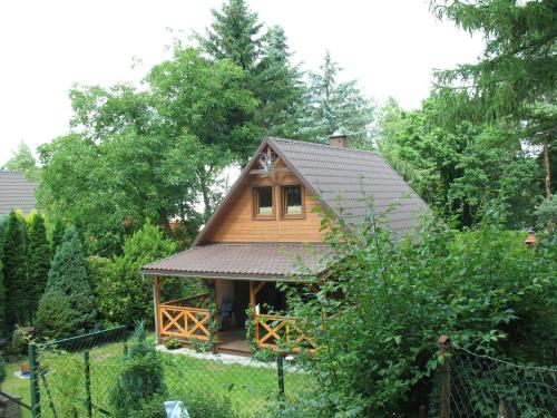 a small house in a garden with a fence at Wilkaski zakątek in Giżycko