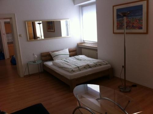 Habitación con cama con espejo y mesa. en CityMinis, en Düsseldorf