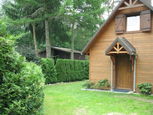 a wooden house with a door and a yard at Wilkaski zakątek in Giżycko