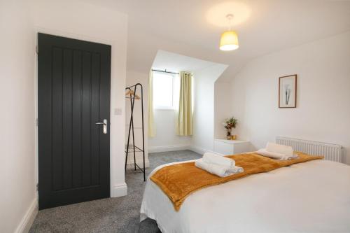 a bedroom with a large bed and a black door at Cudworth House, Barnsley for contractors & Families, off-road parking, speedy WIFI,etc in Barnsley