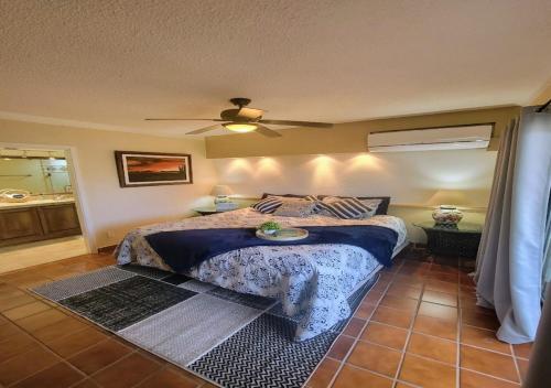 a bedroom with a bed and a ceiling fan at Best Location in Medano Beach -Marina Sol LRG 2 Bed Steps to Beach, Downtown & Marina in Cabo San Lucas