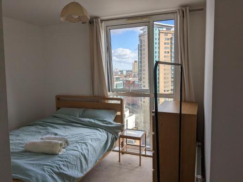 a bedroom with a bed and a large window at 2 Bed 2 baths Apt in Stratford in London
