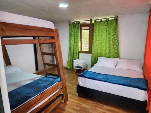 a bedroom with two bunk beds and green curtains at Casa Mirador Alojamiento Campestre in Filandia