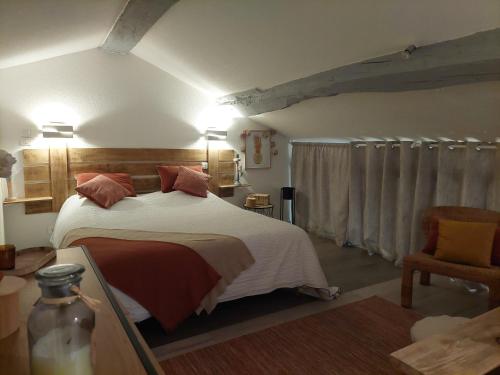 ein Schlafzimmer mit einem großen Bett und einem Stuhl in der Unterkunft Gite Marigot in Bazincourt-sur-Saulx