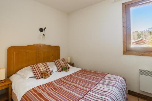 - une chambre avec un lit et une fenêtre dans l'établissement Lagrange Vacances Les Fermes de Samoëns, à Samoëns