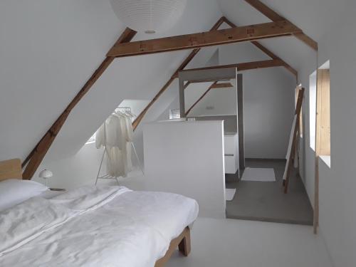 a bedroom with a white bed and a ladder at Maan B&B + Galerie in Kortgene