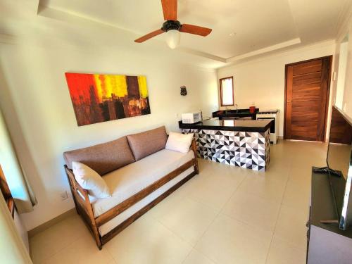 a living room with a couch and a ceiling fan at Pousada Camarás in Alto Paraíso de Goiás