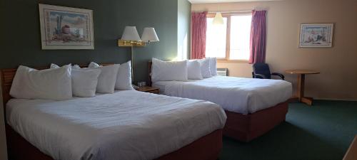 a hotel room with two beds and a window at Travelodge by Wyndham Lacombe in Lacombe