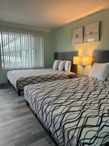 a hotel room with two beds and two lamps at Royal Canadian Motel in Wildwood