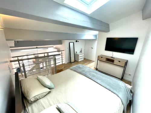 une chambre avec un lit et une télévision à écran plat dans l'établissement New loft 2 bedroom flat cannes croisette / Palais des festivals, à Cannes