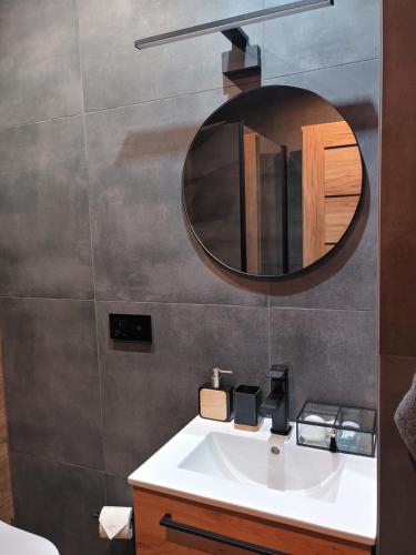 a bathroom with a white sink and a mirror at Leśny Reset in Mrągowo