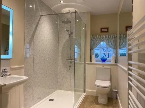 a bathroom with a shower and a toilet and a sink at Spacious cottage - walk to Crieff in Crieff