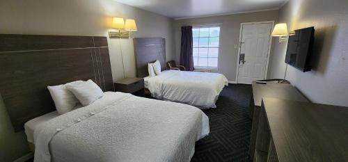 a hotel room with two beds and a television at Alice Motor Inn in Alice