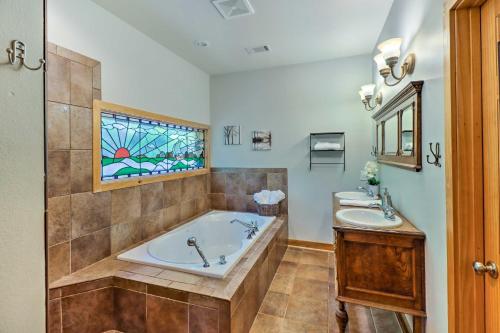 a bathroom with a tub and two sinks and a window at Lakefront Family Escape with Fire Pit and 2 Decks! in Heber Springs