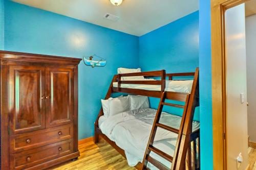 a bedroom with blue walls and a bunk bed at Lakefront Family Escape with Fire Pit and 2 Decks! in Heber Springs