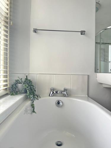 a white bath tub with a faucet in a bathroom at 1 The Croft in Cockermouth