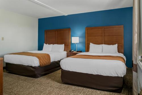 two beds in a hotel room with blue walls at Comfort Inn East Oregon - Toledo in Oregon