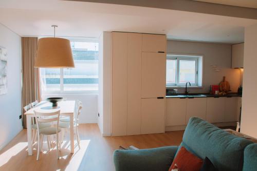 a kitchen and living room with a table and chairs at Just Like Home - Moledo Slow Living in Moledo