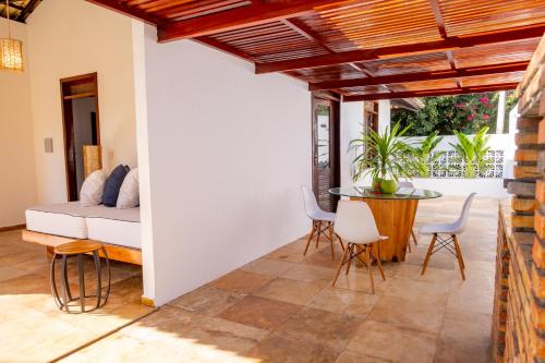 Refugios Parajuru - Casa Pequena في باراجورو: غرفة معيشة مع سرير وطاولة وكراسي