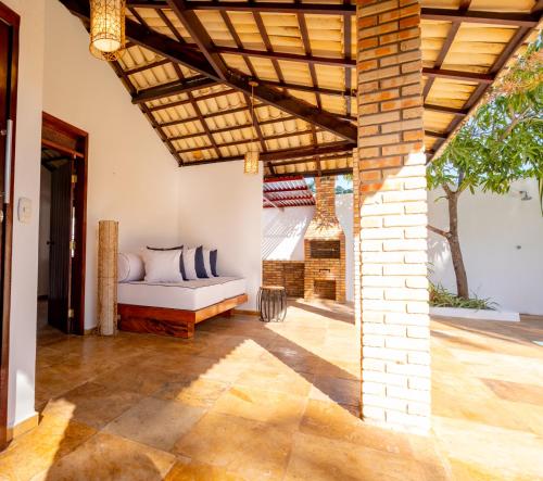 un soggiorno all'aperto con divano sotto un soffitto in legno di Refugios Parajuru - Casa Pequena a Parajuru