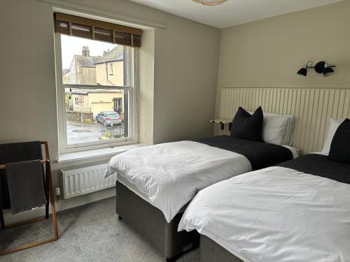 a bedroom with two beds and a window at 1 The Croft in Cockermouth